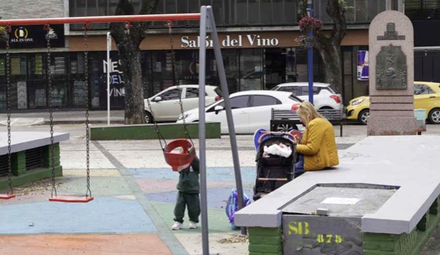La placita hoy: dos hamacas sobre un piso de cemento pintado, con el monumento al fondo